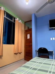 a bedroom with blue walls and a bed and a window at Hospedaje obsesión in Pucallpa