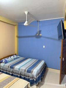 a blue room with a bed and a tv at Hospedaje obsesión in Pucallpa +4 photos