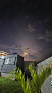 a building with a cloudy sky in front of it at Casa Container Jacu in Lavrinhas +3 photos