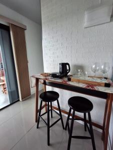 a kitchen with two stools and a counter with wine glasses at Casa Container Jacu in Lavrinhas
