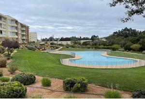 a swimming pool in the middle of a park at Agradable departamento en Papudo in Papudo