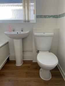 a white bathroom with a toilet and a sink at Liverpool Rose House Stylish 3 Bed Near Anfield and Goodison Park in Liverpool +90 photos