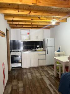 a kitchen with white appliances and a wooden ceiling at Chalten Mountain Loft 8 in El Chalten