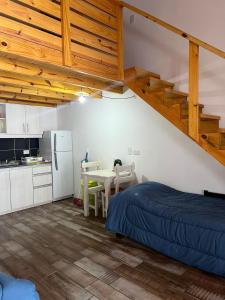 a bedroom with a bed and a table and a kitchen at Chalten Mountain Loft 8 in El Chalten