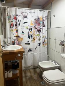 a bathroom with a shower curtain with animals on it at Chalten Mountain Loft 8 in El Chalten