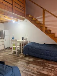 a room with a bed and a table and a staircase at Chalten Mountain Loft 8 in El Chalten