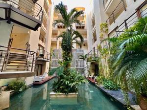 an indoor pool in a building with palm trees at Luxury Boutique Apartments by Xarm Apartments in Santa Marta