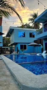 a blue house with a swimming pool in front of it at Kosta Brava Hotel y Restobar in El Majahual