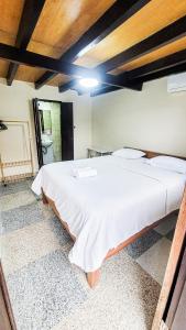 a bedroom with a large white bed in a room at Capung Guesthouse in Jimbaran