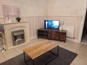 a living room with a tv and a fireplace at Luxury 3 Bedroom House with Parking in Northfleet