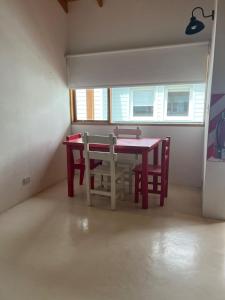a dining room with a red table and chairs at Chalten Mountain Loft 6 in El Chalten