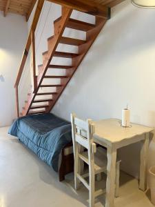 a bedroom with a bed and a table and stairs at Chalten Mountain Loft 6 in El Chalten
