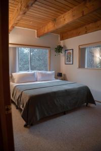 ein großes Bett in einem Zimmer mit einem großen Fenster in der Unterkunft Sunshine Cabin Cozy 3BR Getaway and Deck in Pine Mountain Club