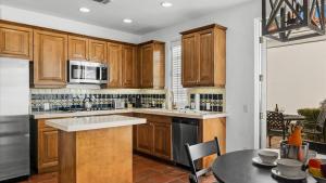 uma cozinha com armários de madeira e uma mesa em SV109 Secluded 1 Bedroom Spa Villa at LQ Resort em La Quinta