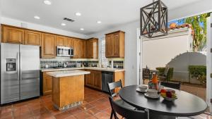 uma cozinha com armários de madeira e uma mesa com cadeiras em SV109 Secluded 1 Bedroom Spa Villa at LQ Resort em La Quinta