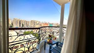 开罗Tiye Pyramids Hotel的带桌子的阳台，可欣赏城市景观