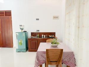 a kitchen with a table and a refrigerator at Villa Yoniky - Weligama in Weligama +47 photos