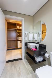 a bathroom with a sink and a mirror at Vilinha típica - Suíte Onze Tuin - Entrada com senha - Somos hospedagem por temporada in Holambra +121 photos