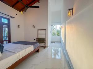 a bedroom with a bed and a chair at Villa Yoniky - Weligama in Weligama