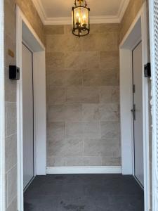 a chandelier in a room with a tiled wall at eco Appartements Reichel in Baden-Baden