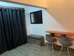ein Zimmer mit einem Tisch, zwei Stühlen und einer Bank in der Unterkunft HaciendaBosque in Cuernavaca