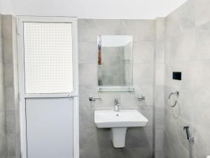 a white bathroom with a sink and a mirror at Villa Yoniky - Weligama in Weligama
