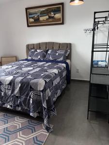 a bedroom with a bed with a blue and white comforter at Sítio Bela Vista in Angra dos Reis