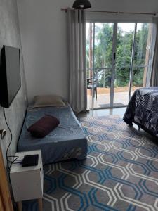 a bedroom with a bed and a flat screen tv at Sítio Bela Vista in Angra dos Reis