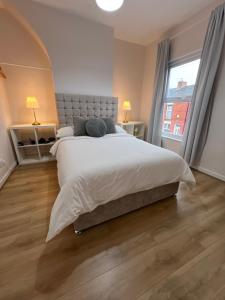 a bedroom with a large bed and a large window at Liverpool Rose House Stylish 3 Bed Near Anfield and Goodison Park in Liverpool