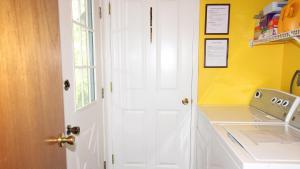 une cuisine avec une porte blanche et un mur jaune dans l'établissement The Lily Pad, à Cape May Point 33 autres photos