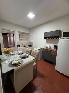 ウベラバにあるComforto-1 min ABCZl 4 min BR050のキッチン(テーブル、椅子、白い冷蔵庫付)