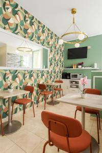 a dining room with tables and chairs and a kitchen at Hotel Aurelia Milano Centrale in Milan