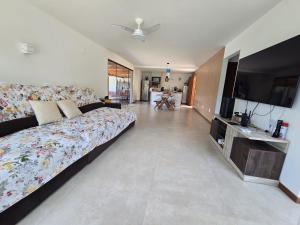 Casa em condomínio Guarapari ES في غواراباري: غرفة نوم بها سرير كبير وتلفزيون بشاشة مسطحة