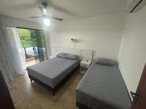 Casa em condomínio Guarapari ES في غواراباري: غرفة نوم بها سريرين ومروحة سقف +36 صورة