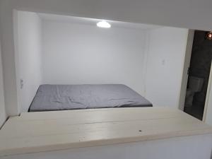 Bett in einem weißen Zimmer mit einer Matratze in der Unterkunft Casa Verde Guest in Saco de Fora + 1 Foto