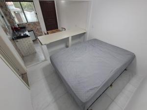 Bett in einem weißen Zimmer mit einem Tisch in der Unterkunft Casa Verde Guest in Saco de Fora