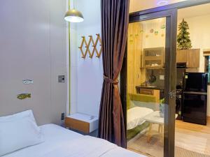 a bedroom with a bed and a sliding glass door at Seashine Apartment in Da Nang