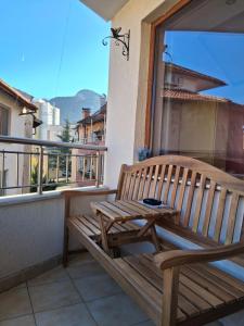 a wooden bench sitting on top of a balcony at Луксозен апартамент in Vratsa