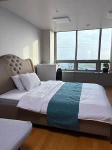 仁川市温馨小屋Cozy House的一间带窗户的房间里有一张大床的卧室