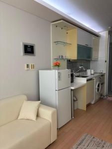 仁川市温馨小屋Cozy House的客厅里有一张沙发和一个厨房