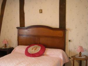 ein Bett mit einem roten Teller darauf in der Unterkunft Maison Authentique en Berry avec Jeux, Jardin, à 30 min du Zoo de Beauval - FR-1-591-119 in Gehée