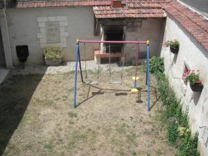 eine Schaukel in einem Hof neben einem Haus in der Unterkunft Maison rustique avec salle de jeux, jardin, 5 chambres près du Zoo de Beauval - FR-1-591-34 in Gehée