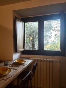 eine Küche mit 2 Fenstern und einem Tisch mit Stühlen in der Unterkunft Dimidia - casa vacanze mare montagna in Capaci + 21 Fotos