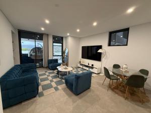 a living room with a blue couch and a table at The Gosford Modern Nest in Gosford