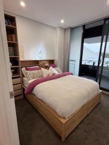 Un dormitorio con una cama con un osito de peluche encima. en The Gosford Modern Nest, en Gosford