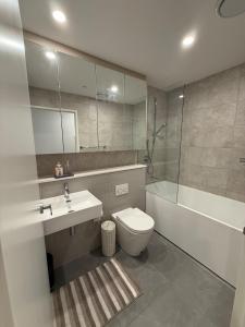 Un baño con inodoro, lavabo y bañera. en The Gosford Modern Nest, en Gosford