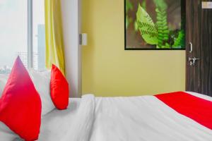浦那Collection O Baner Hillview Pune Formerly Siri Lodge的卧室配有红色和白色的枕头