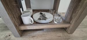 una estantería de madera con un plato y gafas. en Relaxing Lake side Master Room with Ensuite, en Kelmscott