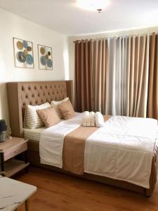a bedroom with a large bed with white sheets and pillows at Cozy 2BR Seawind Near Airport and Samal Island in Davao City