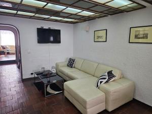 ein Wohnzimmer mit Sofa und Fernseher in der Unterkunft La Casa in Bogotá